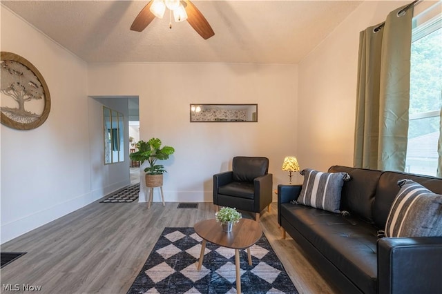 living room with ceiling fan, wood-type flooring, and a textured ceiling