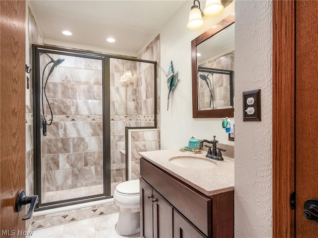 bathroom with vanity, toilet, and a shower with shower door