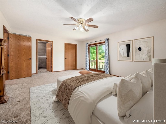 carpeted bedroom with ceiling fan, ensuite bath, access to exterior, and a textured ceiling