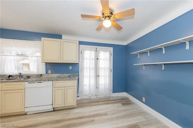 kitchen with white dishwasher, light wood-type flooring, sink, and a wealth of natural light