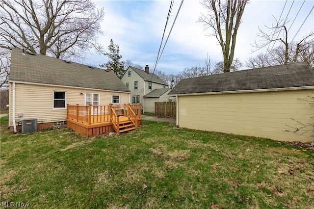 back of house with central AC unit, a deck, and a lawn