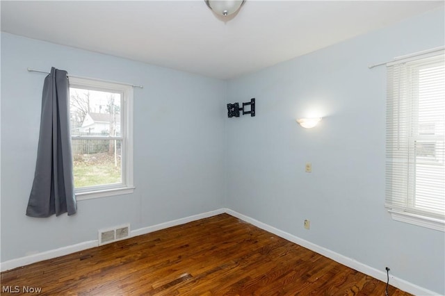 unfurnished room with dark wood-type flooring