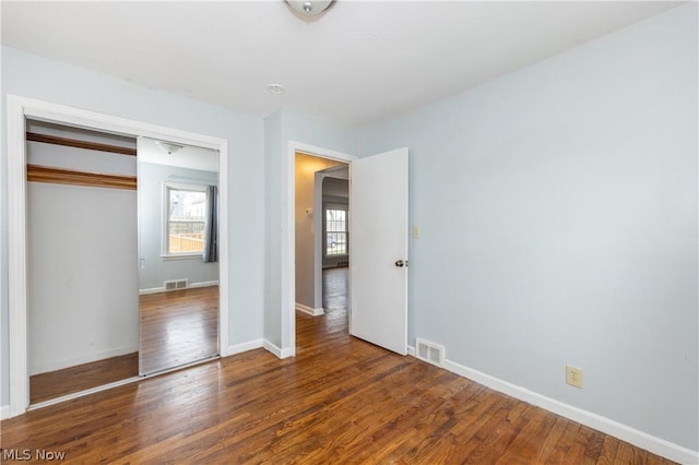 unfurnished bedroom with hardwood / wood-style flooring and a closet