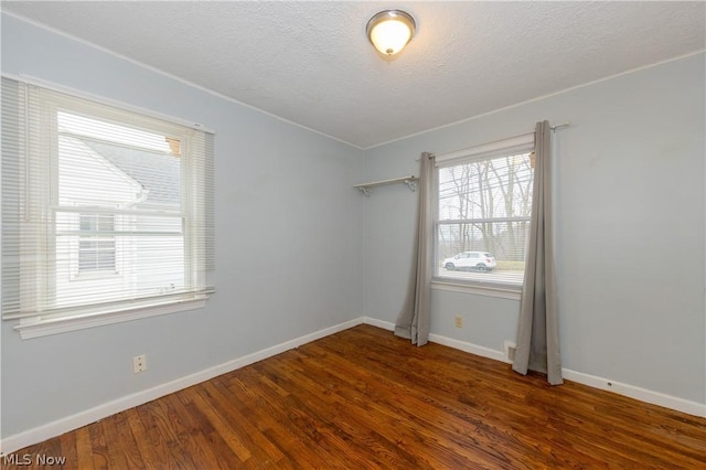 unfurnished room with dark hardwood / wood-style floors and a textured ceiling