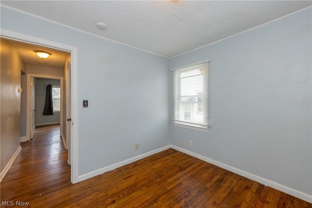 spare room with dark hardwood / wood-style flooring and a textured ceiling