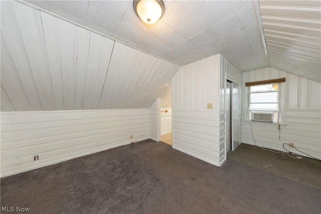 bonus room with cooling unit, dark carpet, and vaulted ceiling