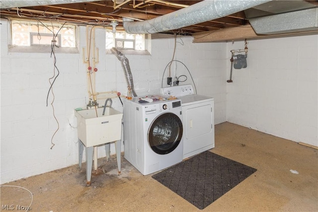 laundry room featuring washing machine and dryer, sink, and a healthy amount of sunlight