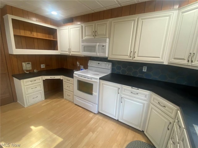 kitchen with white cabinetry, white appliances, built in desk, and light hardwood / wood-style flooring