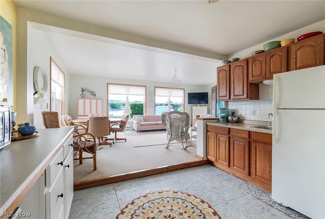 6579 Camp Blvd, Hanoverton, OH 44423 - kitchen featuring a sink, brown cabinetry, light countertops, freestanding refrigerator, and light colored carpet