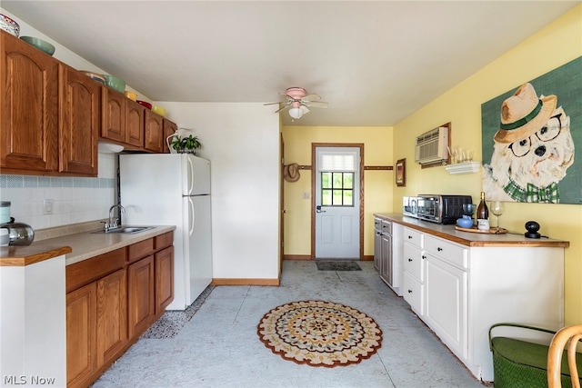 kitchen with white fridge, light tile flooring, ceiling fan, tasteful backsplash, and sink