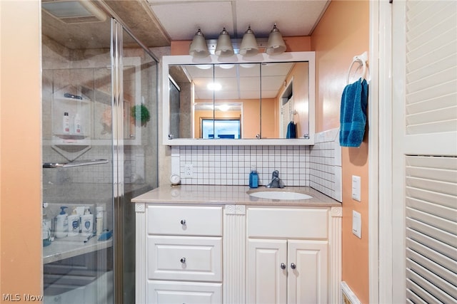 bathroom featuring a shower with door, tasteful backsplash, and oversized vanity