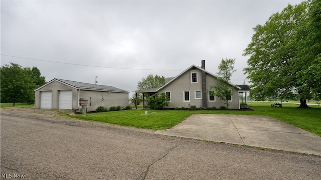 view of front of house with a front lawn, a garage, and an outdoor structure