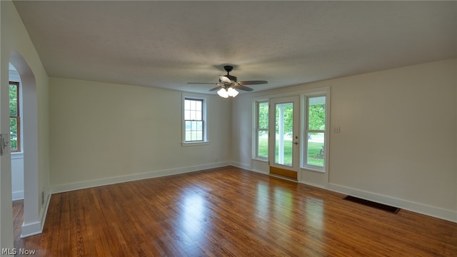 empty room featuring dark wood-type flooring and ceiling fan