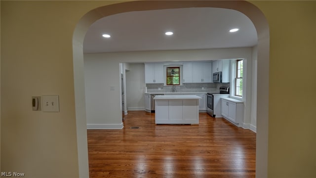 kitchen featuring stainless steel appliances, white cabinetry, and hardwood / wood-style flooring