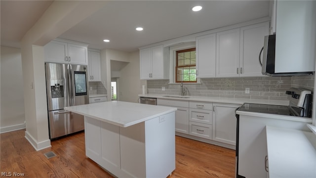 kitchen featuring sink, light hardwood / wood-style floors, white cabinetry, and appliances with stainless steel finishes