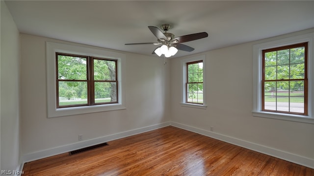 spare room with hardwood / wood-style floors and plenty of natural light