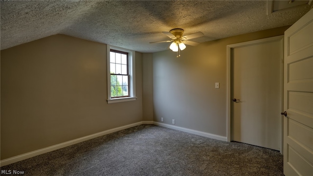 unfurnished room with dark colored carpet, ceiling fan, a textured ceiling, and lofted ceiling