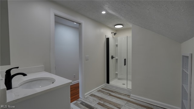 bathroom featuring an enclosed shower, a textured ceiling, vanity, and hardwood / wood-style floors