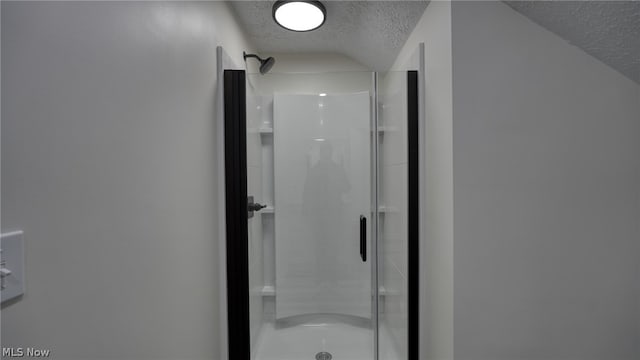 bathroom featuring walk in shower and a textured ceiling