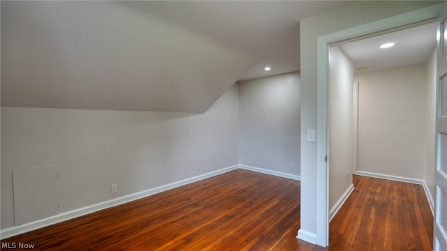 bonus room featuring vaulted ceiling and dark wood-type flooring