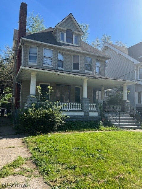 view of front of home with a front yard and covered porch