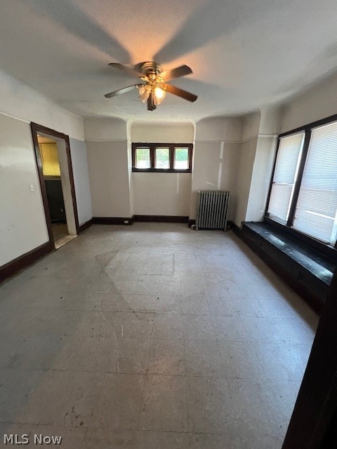 unfurnished bedroom featuring ceiling fan and radiator heating unit