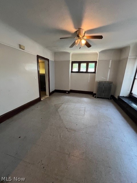 unfurnished bedroom featuring radiator heating unit and ceiling fan