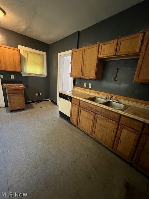 kitchen featuring sink, dishwasher, and light tile floors