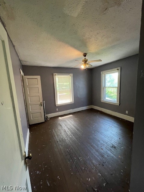 unfurnished bedroom featuring hardwood / wood-style floors, ceiling fan, and a textured ceiling