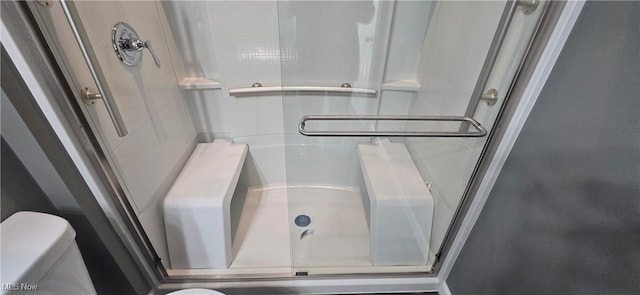 bathroom featuring toilet and an enclosed shower