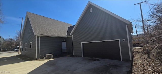 view of property exterior with central air condition unit, roof with shingles, and driveway