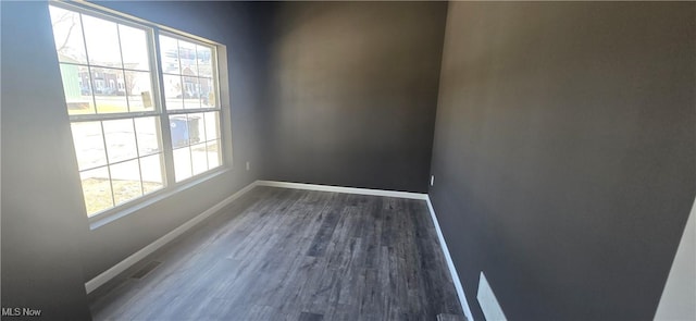 unfurnished room featuring baseboards and wood finished floors