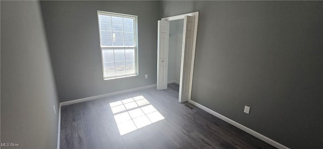 empty room featuring baseboards and wood finished floors
