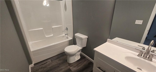 full bath featuring bathtub / shower combination, toilet, wood finished floors, and vanity