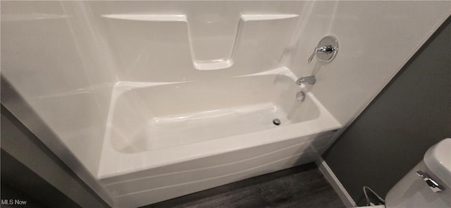 full bathroom with shower / tub combination, wood finished floors, and toilet