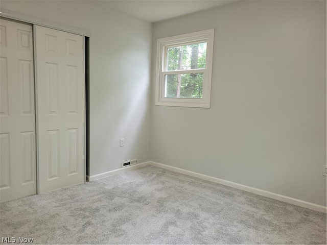 unfurnished bedroom featuring carpet and a closet