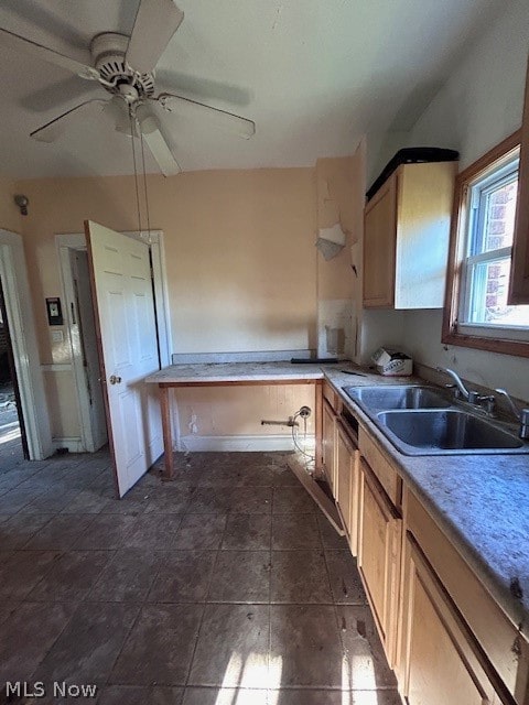 kitchen with sink, dark tile flooring, ceiling fan, and light brown cabinetry