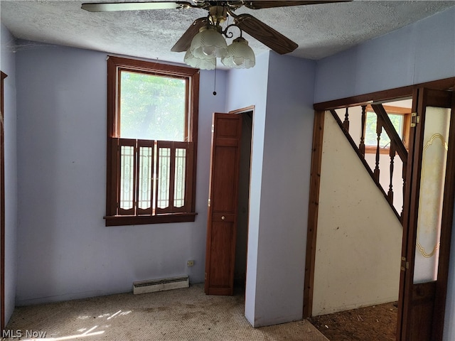 carpeted spare room featuring ceiling fan and a textured ceiling