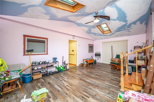 interior space featuring vaulted ceiling with skylight, ceiling fan, and hardwood / wood-style floors