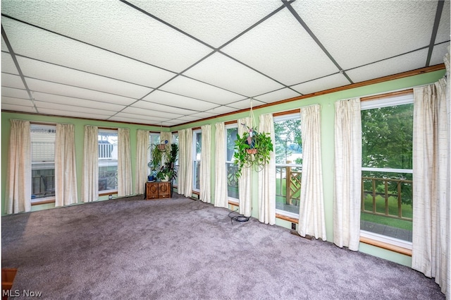 unfurnished sunroom featuring a wealth of natural light and a drop ceiling