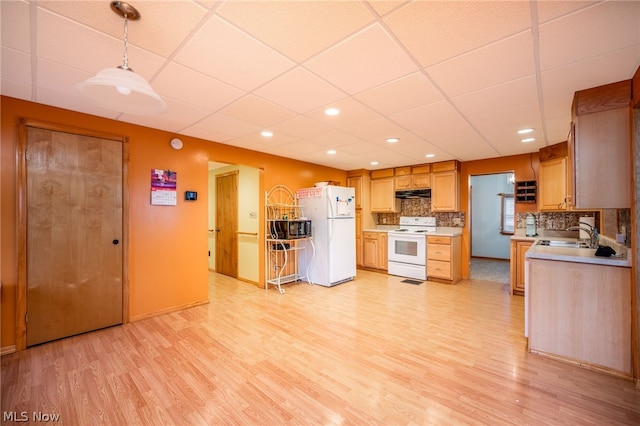 kitchen featuring light hardwood / wood-style floors, hanging light fixtures, white appliances, backsplash, and a drop ceiling