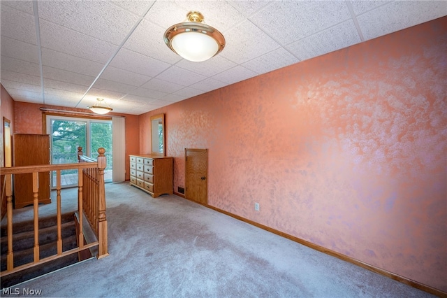 carpeted spare room with a drop ceiling