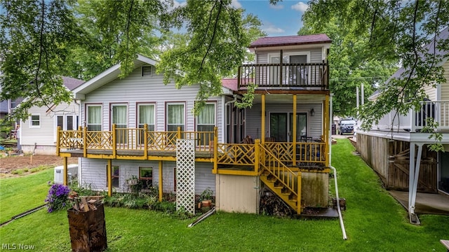 back of house featuring a lawn, a balcony, and a wooden deck