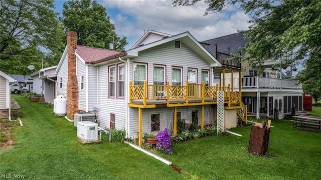 back of property featuring central AC and a lawn