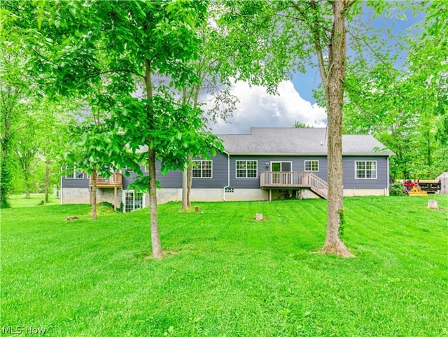 rear view of property with a deck and a yard