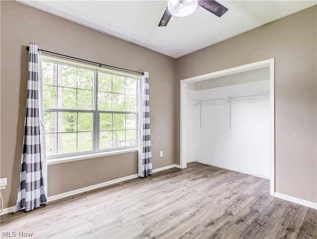 unfurnished bedroom featuring ceiling fan, light wood-type flooring, and a closet