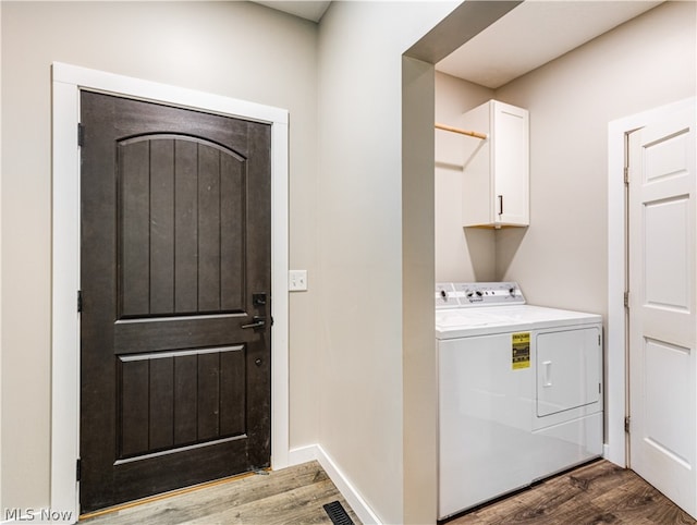 laundry area with hardwood / wood-style flooring and cabinets