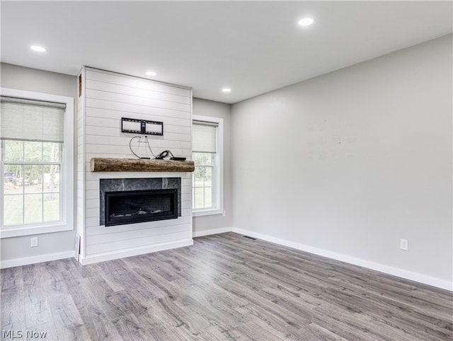 unfurnished living room featuring a fireplace and light hardwood / wood-style flooring