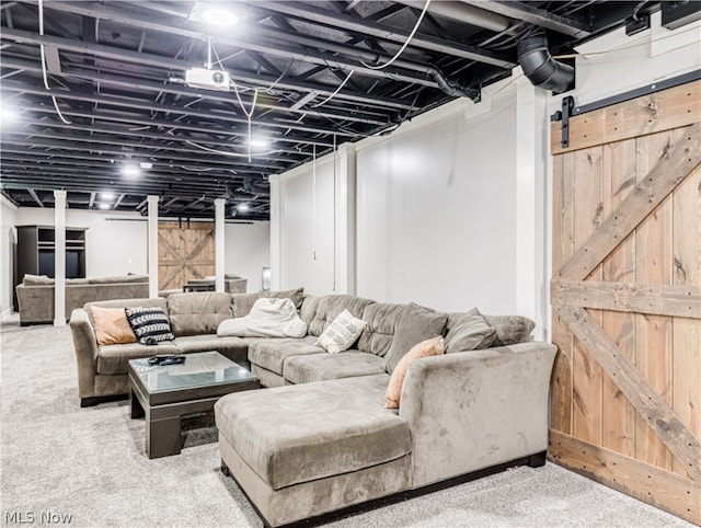 living room with a barn door and carpet floors