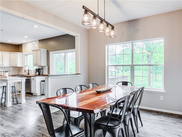 dining space with light hardwood / wood-style flooring and sink